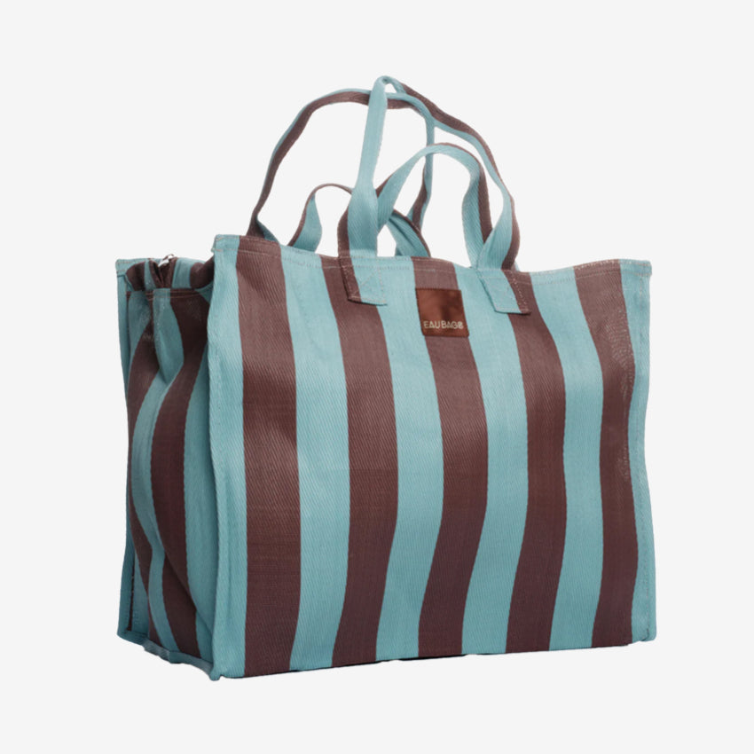 The EAU Vacay Bag in Iced Chocolate on a grey background