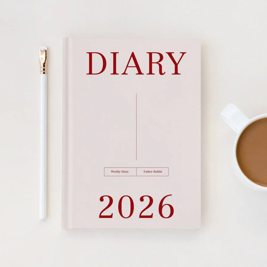 The Father Rabbit 2025 Weekly Diary in Dusk design next to a white pencil and coffee