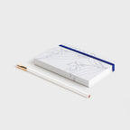 The Father Rabbit Hardcover Notebook in Blue Jasmine on a desk with a pencil