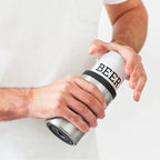 A guy putting a beer can in the Huski Beer Cooler in Stainless Steel 