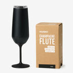 The Huski Champagne Flute in Black next to its box on a blank background