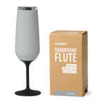 The Huski Champagne Flute in Stone Grey next to its box on a blank background