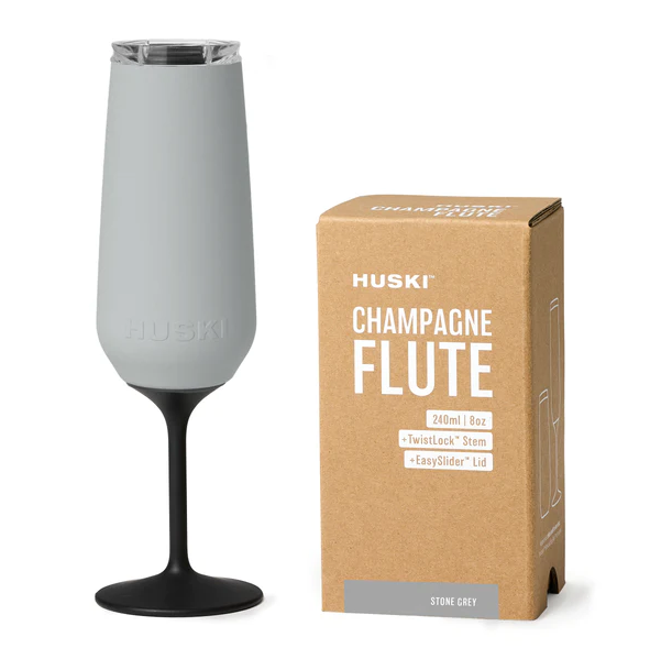 The Huski Champagne Flute in Stone Grey next to its box on a blank background