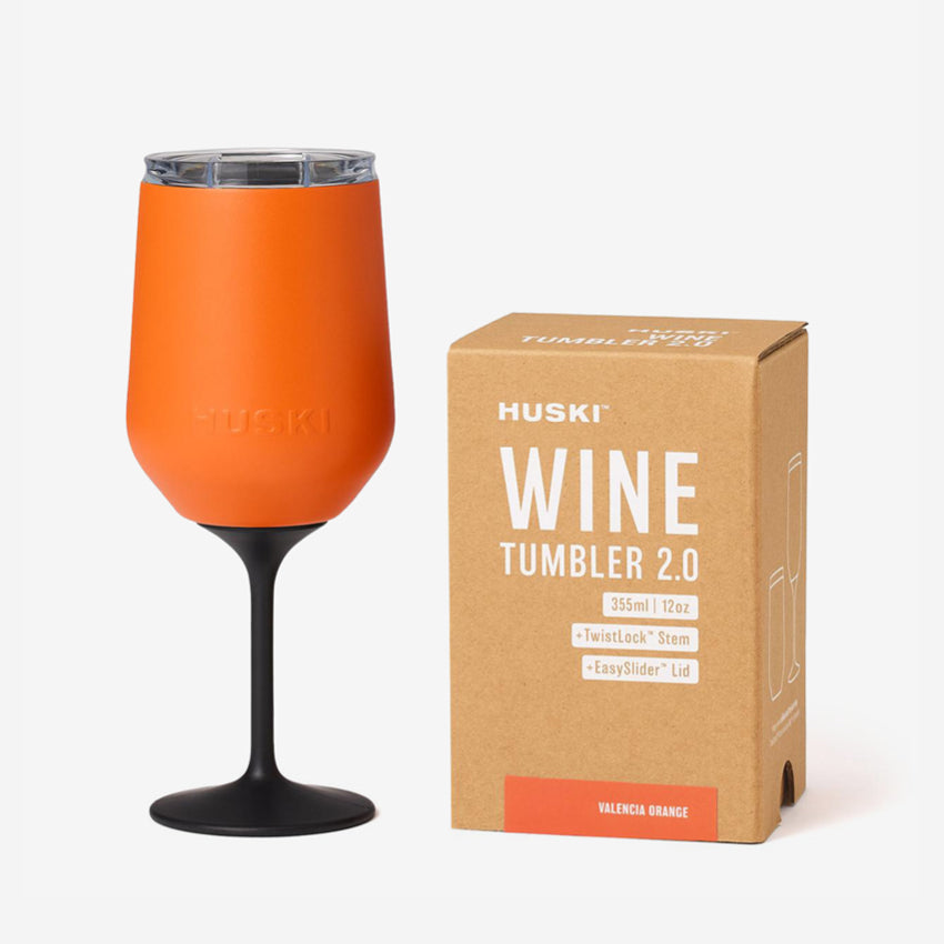 The Huski Wine Tumbler 2.0 in Valencia Orange next to its box on a blank background