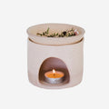 The JS Ceramics Ceramic Oil Burner in Pink Sand with Manuka in it and candle in the bottom on a blank background