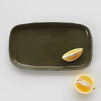 The JS Ceramics Rectangle Platter in Sage Green with lemon slices on it on a blank background