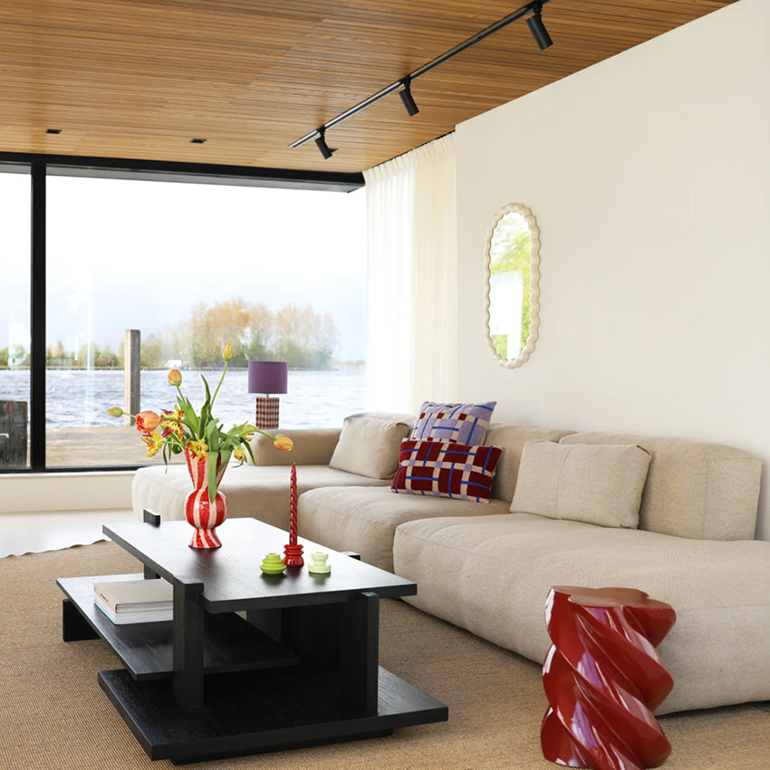 The &Klevering Marshmallow Pillar in Burgundy in a home next to a couch