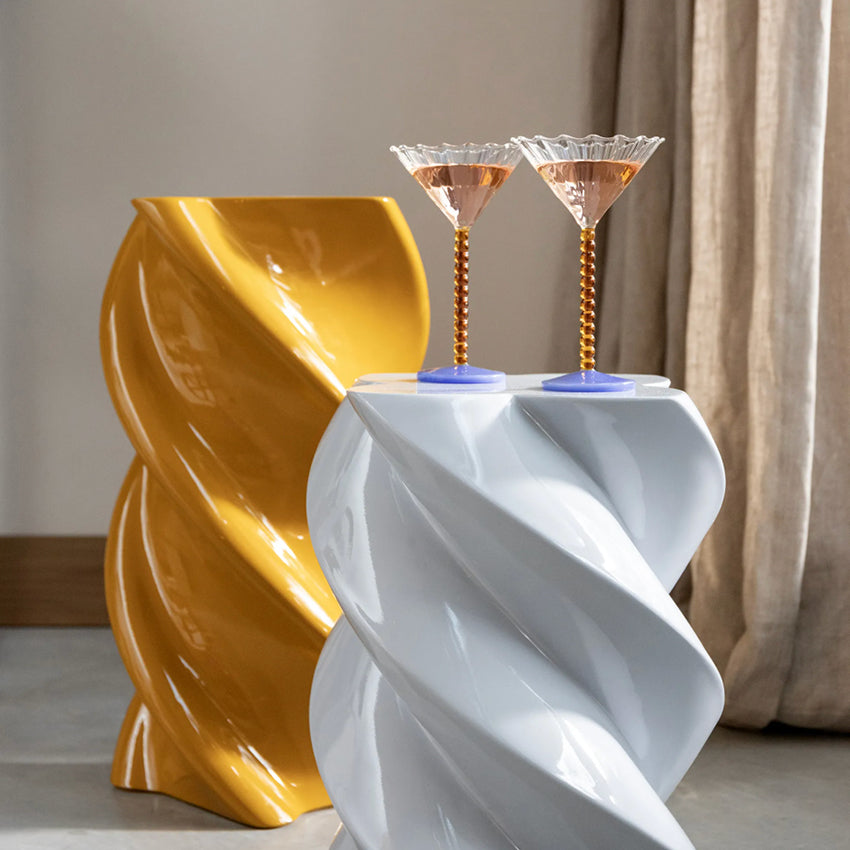 The &Klevering Marshmallow Pillar in Ocher in a home setting next to blue marshmallow pillar with martini glasses on it