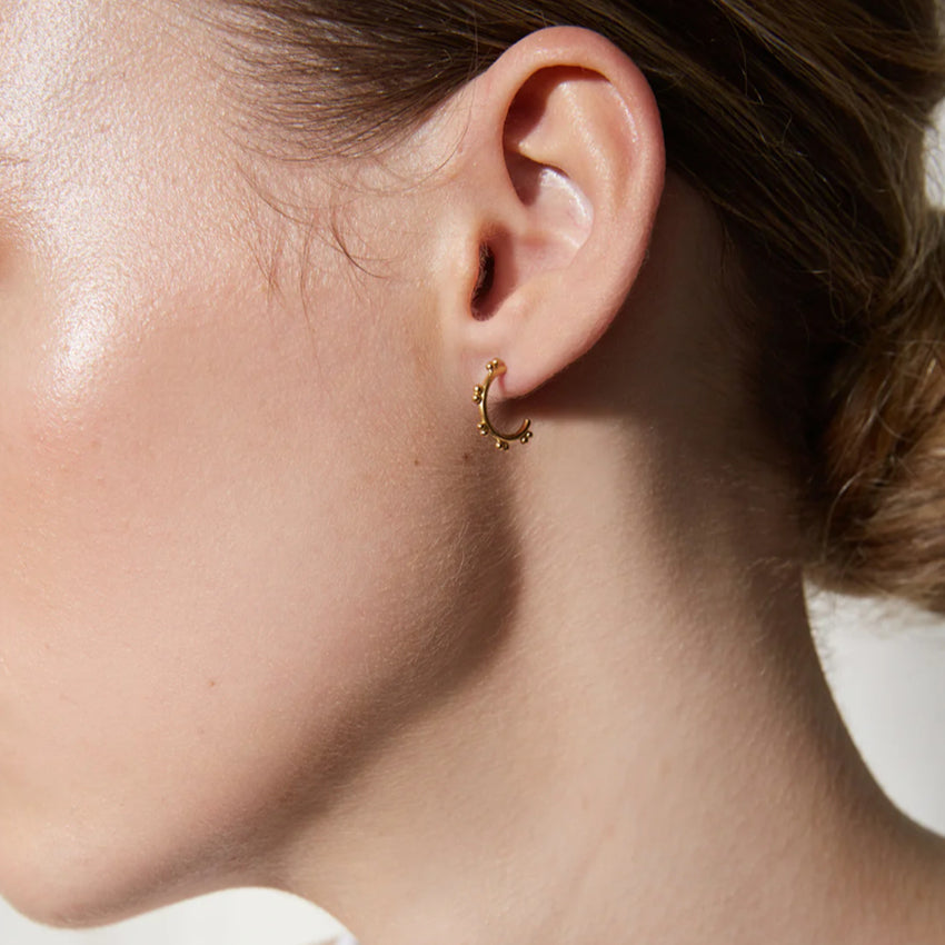 The La Tribe Hoop Studs in gold on a model