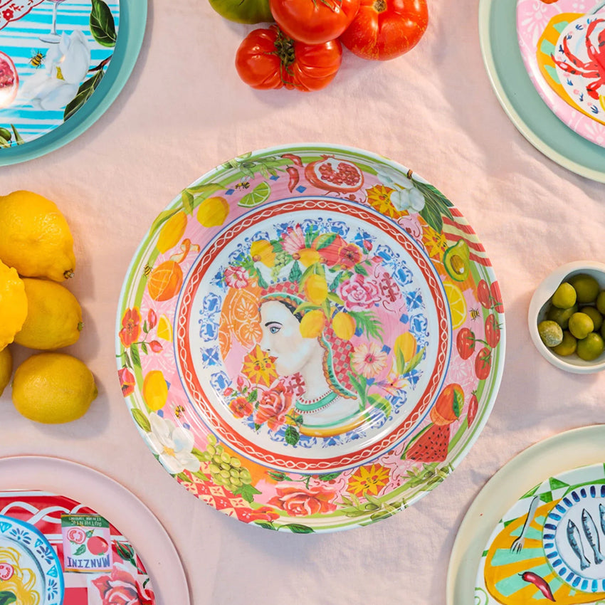 The La La Land Italian Summer Melamine Salad Bowl on a pink tablecloth with other serveware and fruit