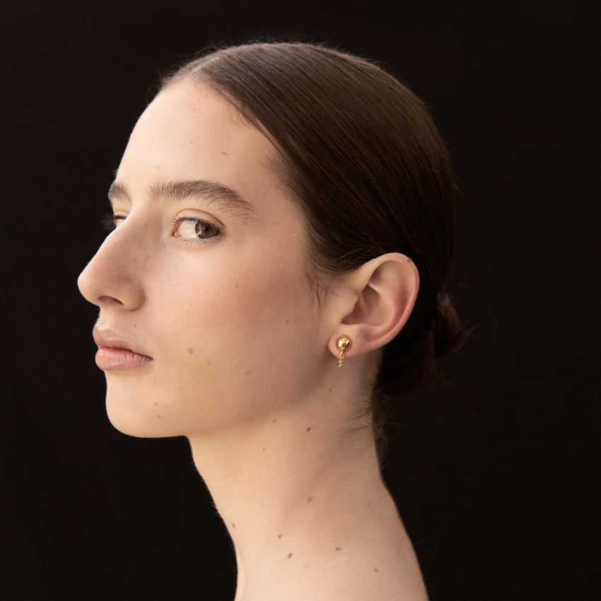 The La Tribe Ball and Chain Studs in Gold on a model