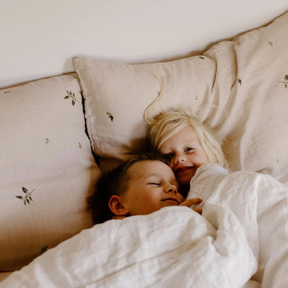 Leni The Label Muslin Pillowcase in Gum on a bed with two kids