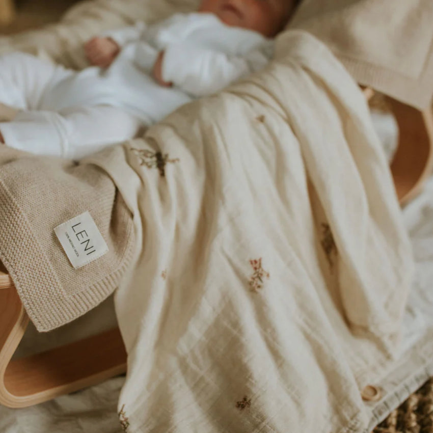 Leni The Label Muslin Swaddle Blanket in Kanuka hanging over a baby chair