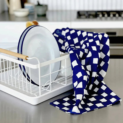 The Lettuce Linen Tea Towel in Hand-drawn Checkers in a kitchen hanging off a Yamazaki dish rack