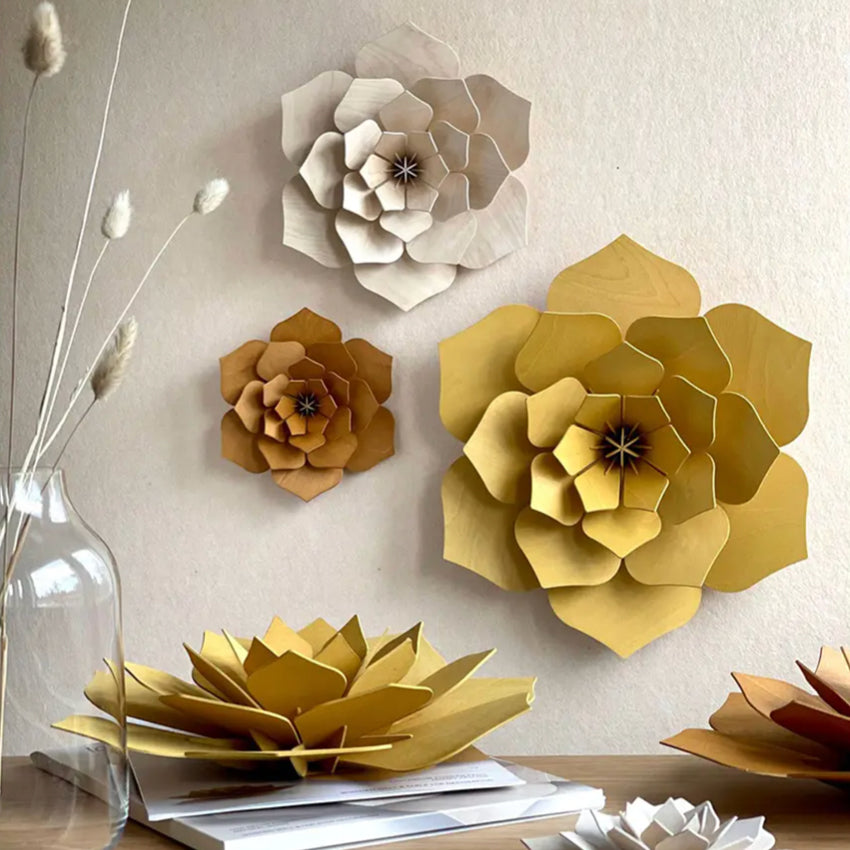 The Lovi 3D Flower Decor in honey hanging on a wall with other coloured Lovi 3D Flowers