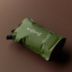 The Matakana Essentials Hand and Body Wash refill pouch lying down on a brown background