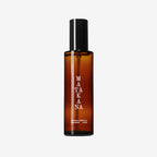 The Matakana Essentials Room Spray brown bottle on a grey background