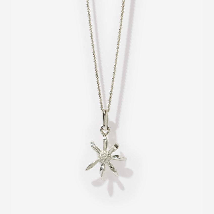 The Meadowlark Daisy Charm Necklace in Sterling Silver on a blank background