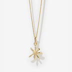 The Meadowlark Daisy Charm Necklace in Gold on a blank background