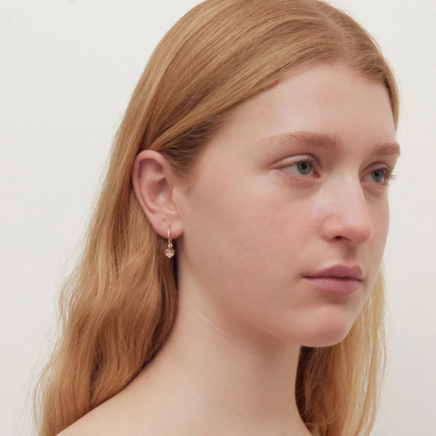 The Meadowlark Dice Signature Hoops in Gold on a model 