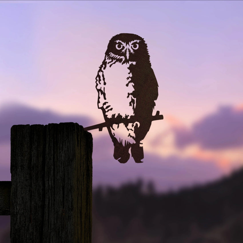 The Metalbird Ruru garden sculpture in a post with a sunset background