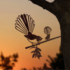 The Metalbird steel Piwakawaka and Baby in a tree with a sunset background