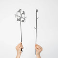 The Metalbird Kereru Pair Plant Stake separated with hands holding them on a blank background