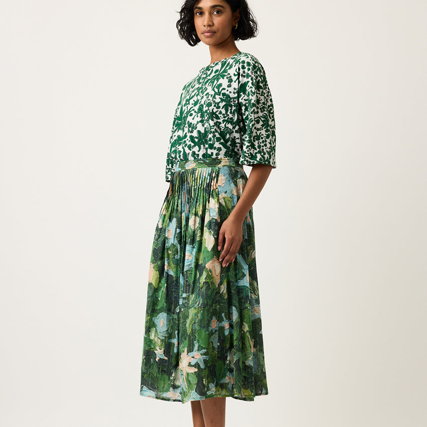 A side view of the Nancybird Alma Yoke Skirt in Garden Print on a model