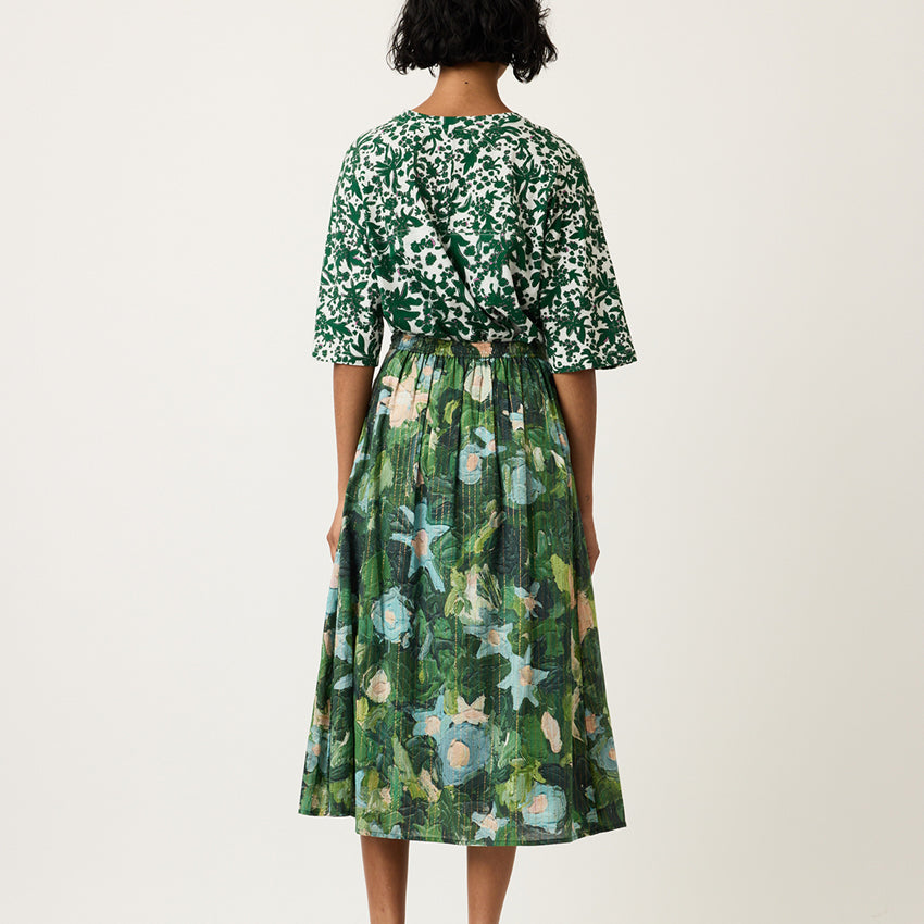 A back view of the Nancybird Alma Yoke Skirt in Garden Print on a model
