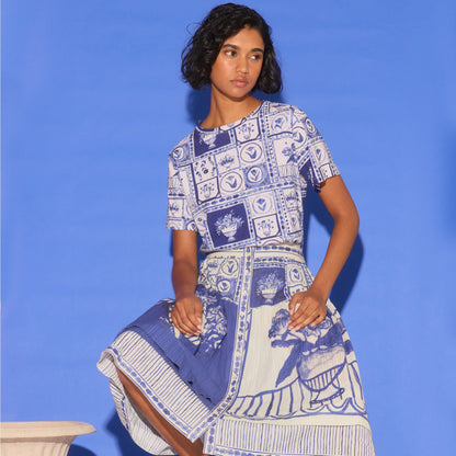 The Nancybird Coco Pintuck Skirt in Lyon Tile on a model with matching skirt on a blue background