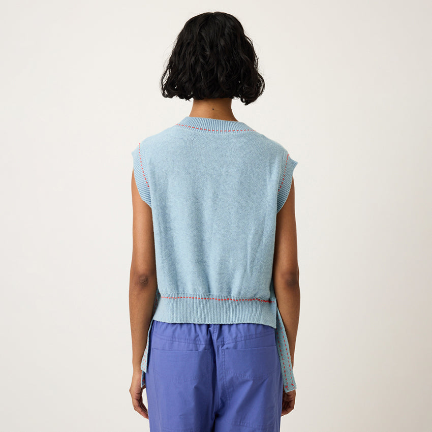A back view of the Nancybird Aria Vest in Flower on a model on a grey background