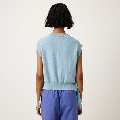 A back view of the Nancybird Aria Vest in Flower on a model on a grey background