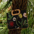 The Nancybird Floratone Beaded Bag hanging on a tree