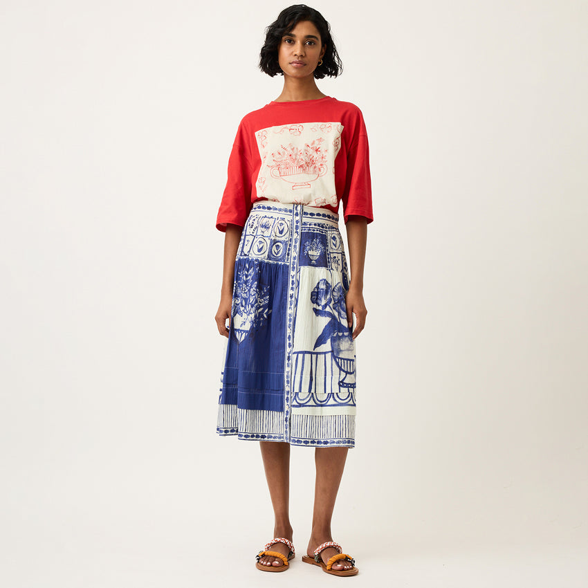 The Nancybird Coco Pintuck Skirt in Lyon Tile on a model with a red tshirt