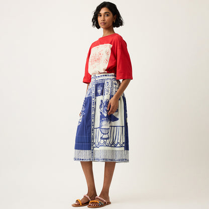 The Nancybird Coco Pintuck Skirt in Lyon Tile on a model turned to the side with a red tshirt