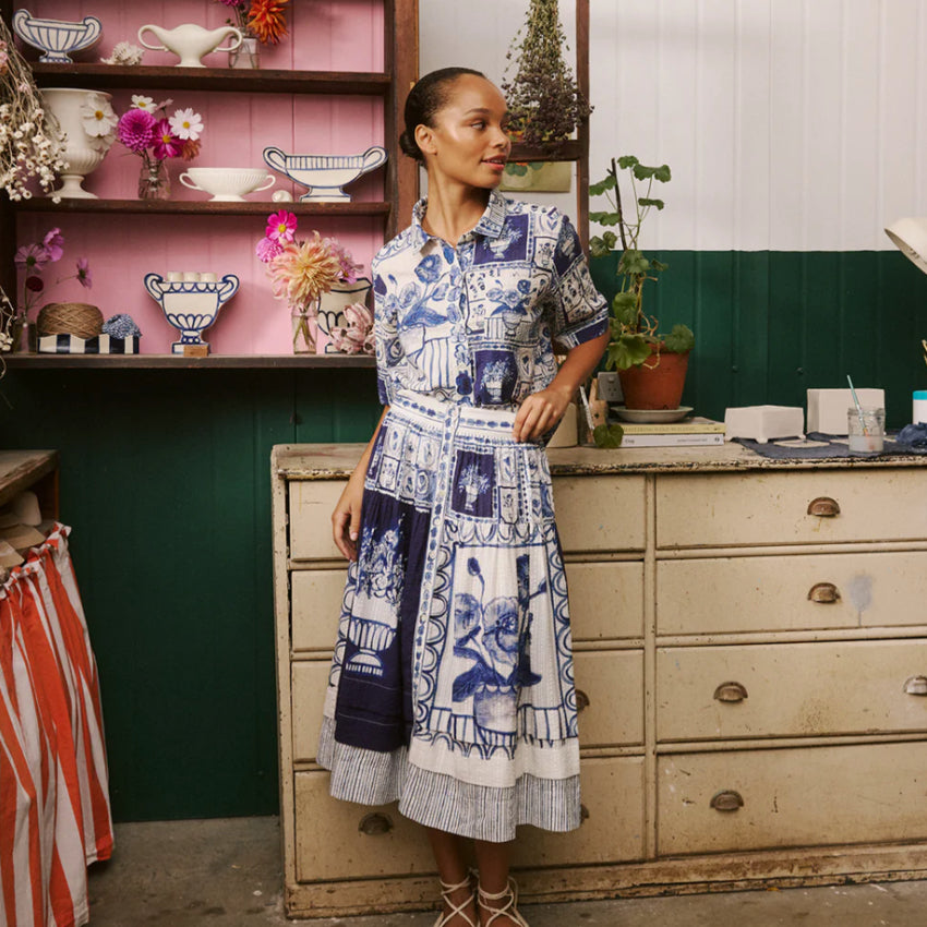 The Nancybird Coco Pintuck Skirt in Lyon Tile on a model with matching shirt infront of drawers and a shelf