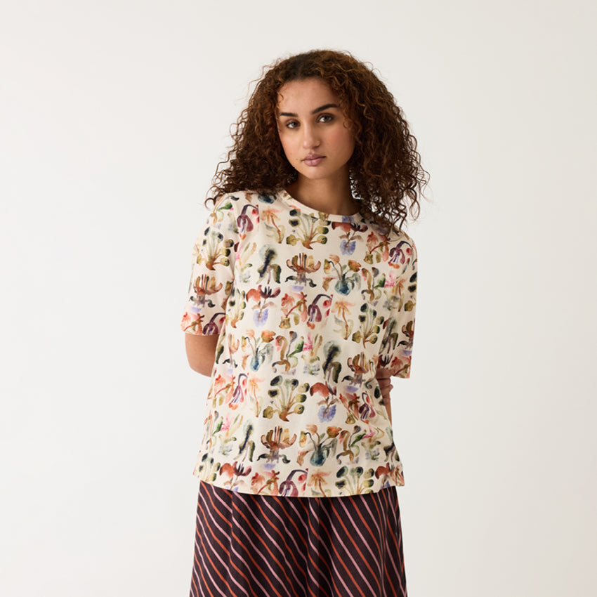 The Nancybird Grace Tee in Warm Watercolour on a model on a grey background