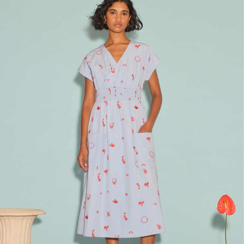 The Nancybird Hana Dress in Motif Embroidery on a model next to a vase and flower