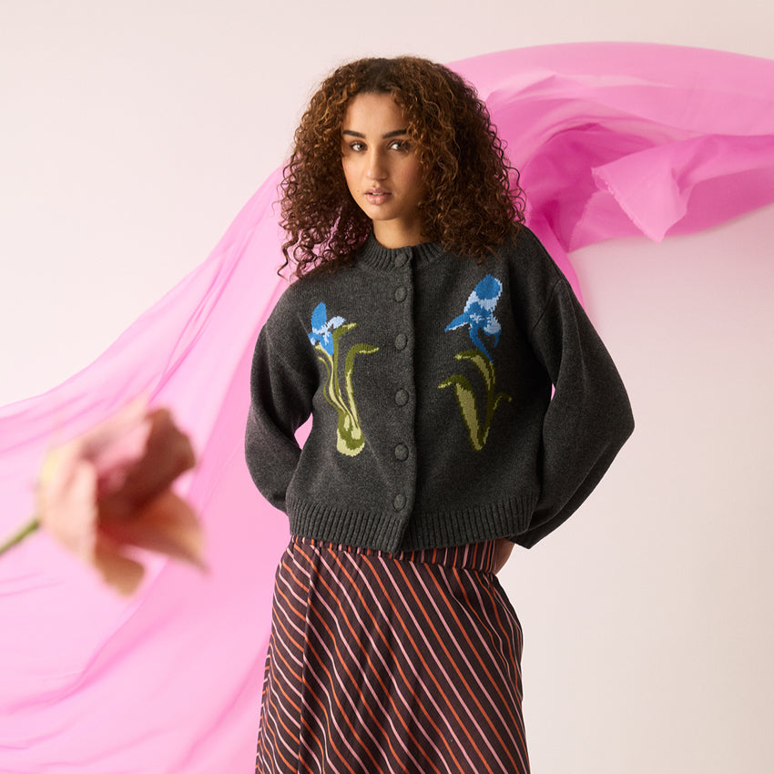 The Nancybird Iris Cardigan on a model with pink fabric behind her