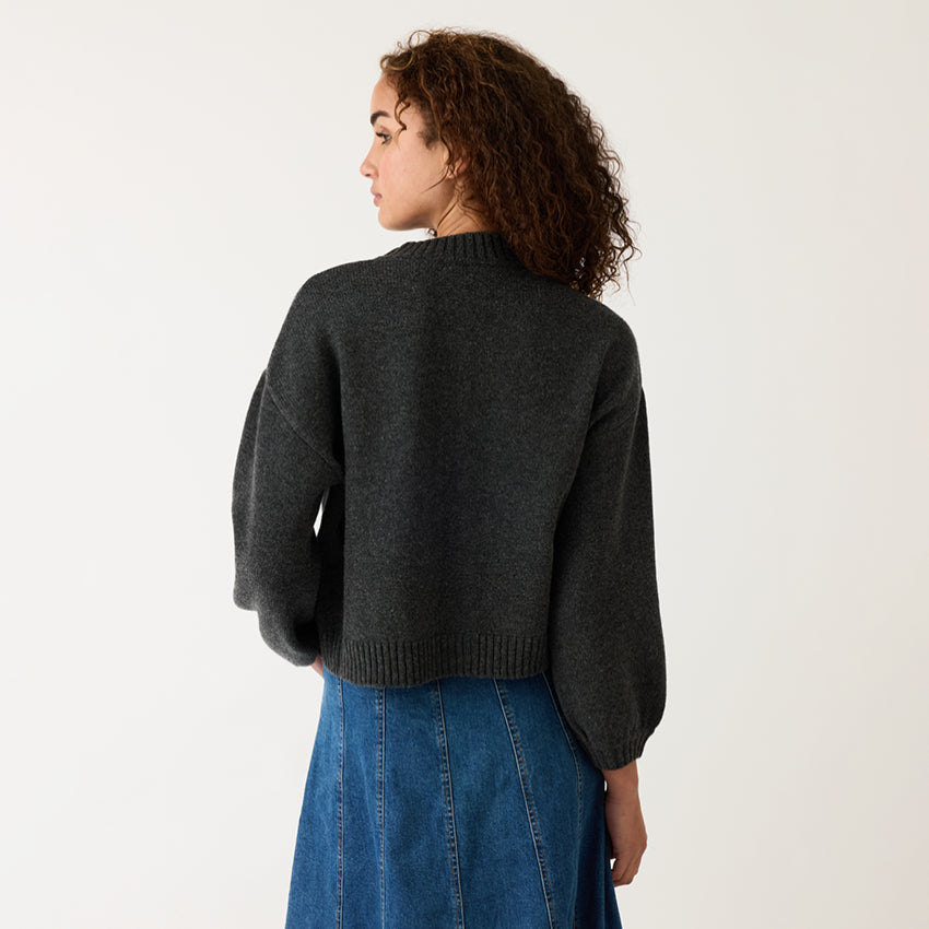 A back view of the Nancybird Iris Cardigan on a model on a grey background