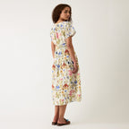 A back view of the Nancybird Lola Dress in Watercolour Collage on a model on a grey background