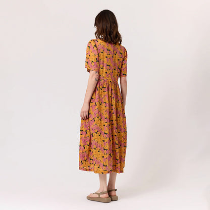 The back view of the Nancybird Alba Dress in Sunset Floral on a model on a blank background