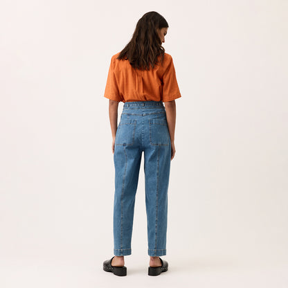 A back view of the Nancybird Amos Pant in Denim on a model on a blank background