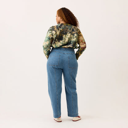 A back view of the Nancybird Amos Pant in Denim on a model on a blank background