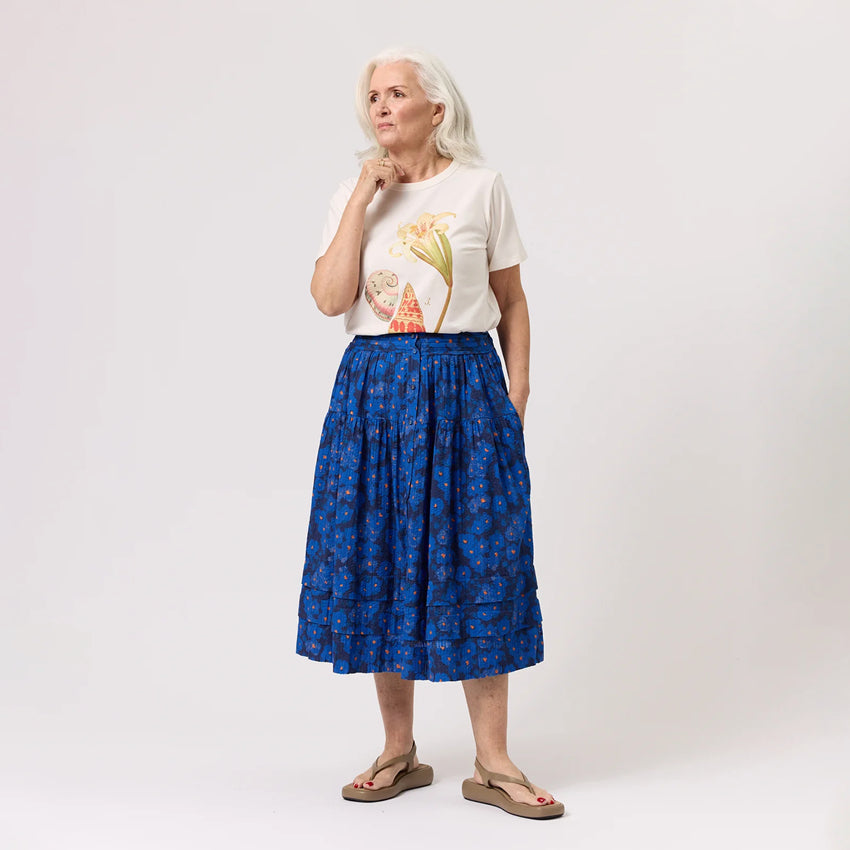 The Nancybird Coco Pintuck Skirt in Midnight Floral on a model paired with a tshirt on a blank background