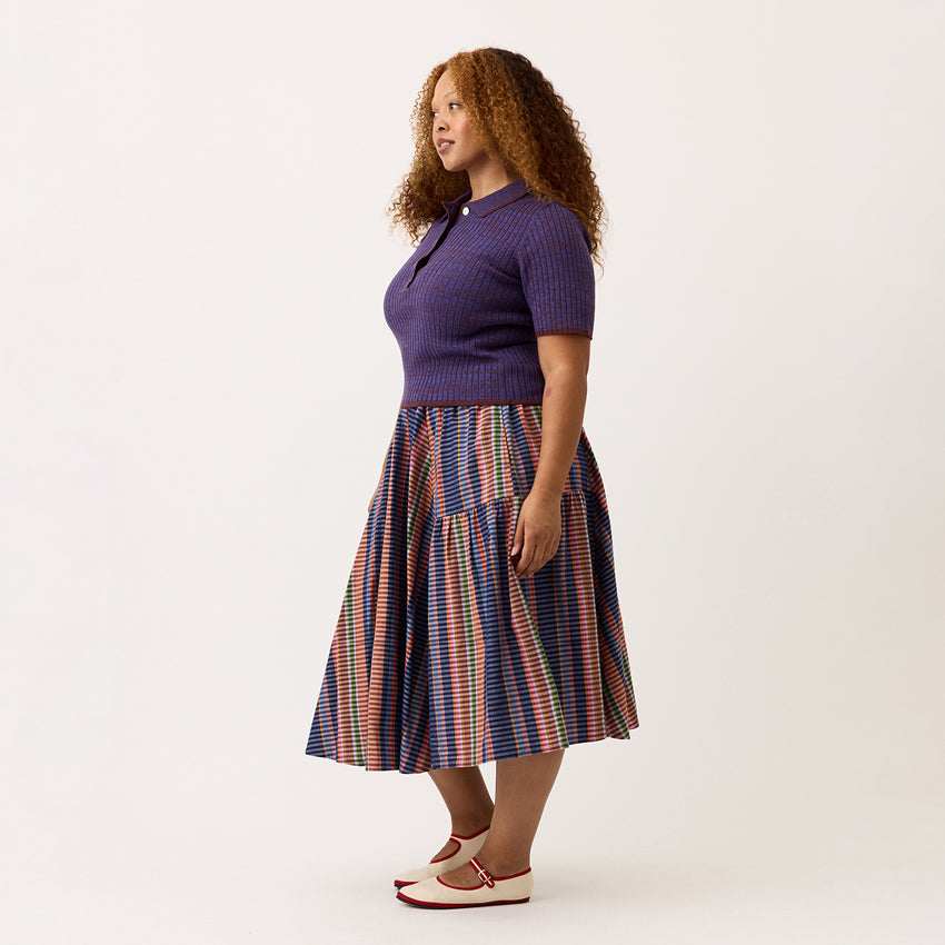 A side view of the Nancybird Eula Skirt in Line Check on a model on a blank background