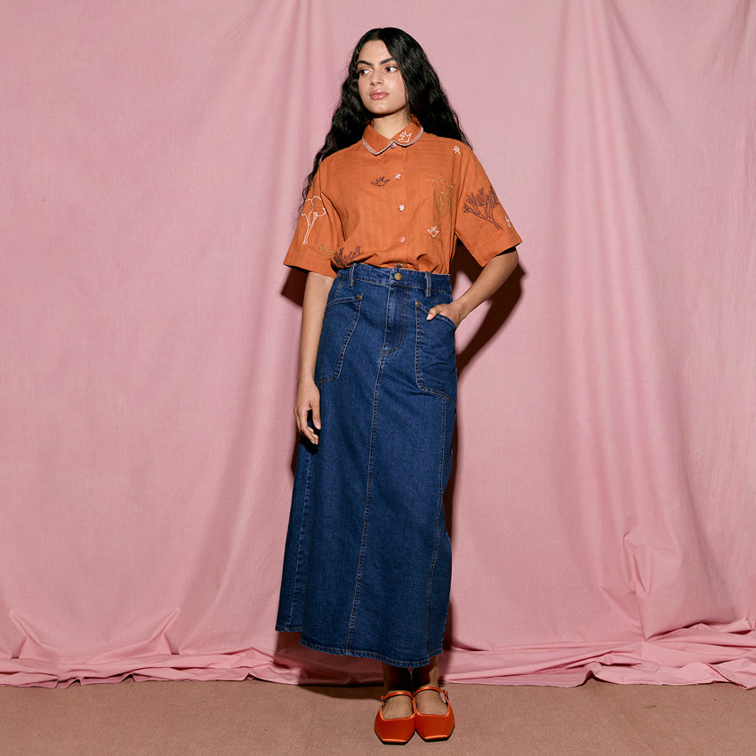 The Nancybird Franny Skirt in Denim on a model with a pink background