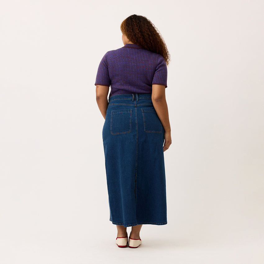 A back view of the Nancybird Franny Skirt in Denim on a model with a blank background