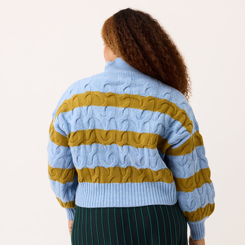 A back view of the Nancybird Gemma Cable Knit in Day Break on a model on a blank background