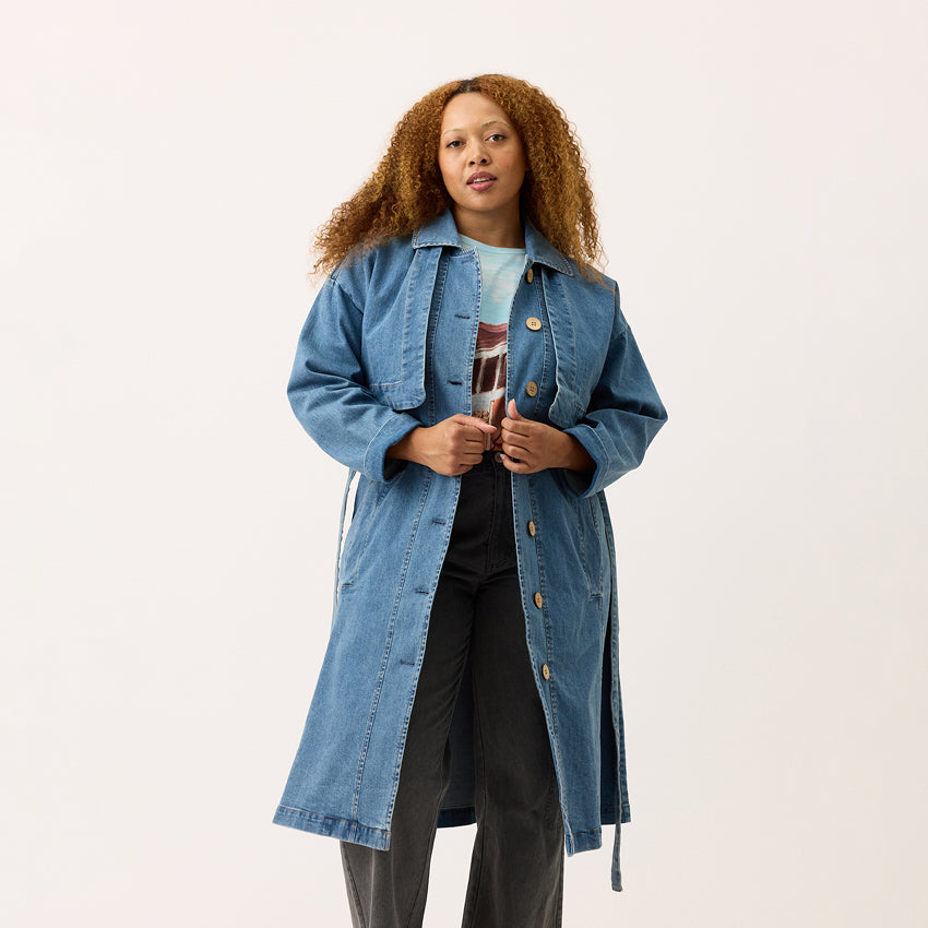 The Nancybird Linu Trench in Denim on a model on a blank background